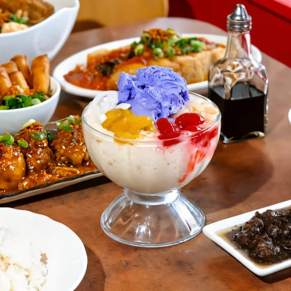 A halo-halo dessert with purple ube ice cream, surrounded by various Filipino dishes on a wooden table.